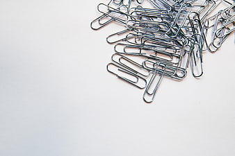 Silver paper clips on white background with copy space