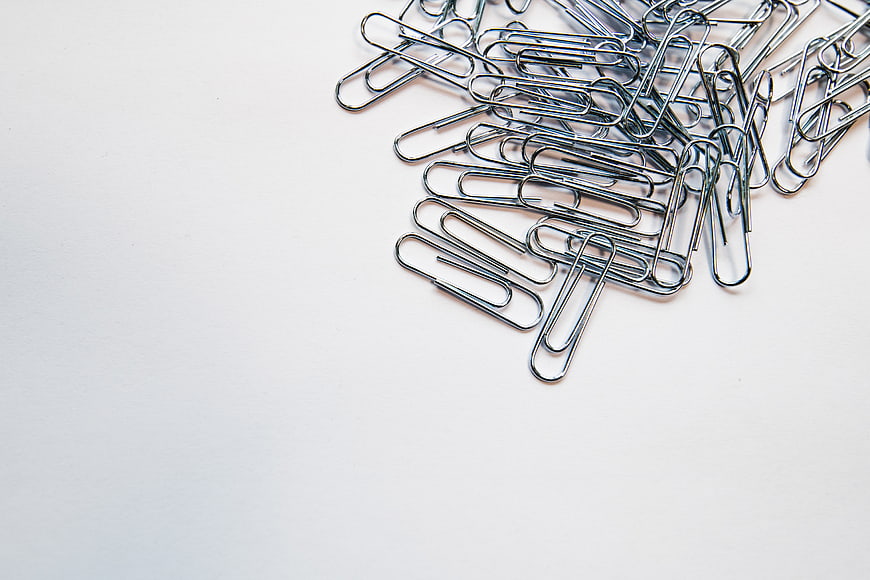 Silver paper clips on white background with copy space