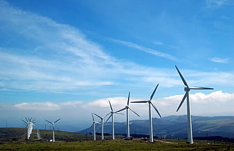 Wind Turbines on Green Hillside Under Blue Sky
