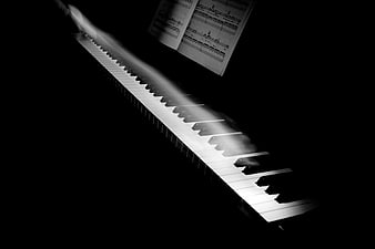 Motion blur of hands playing piano keys with sheet music