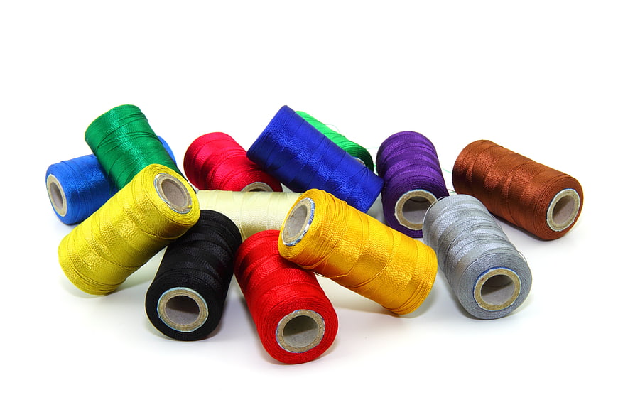 Assorted Colorful Spools of Embroidery Thread on White Background