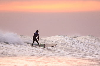 Surfer Riding Wave at Sunset Ocean