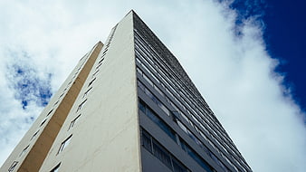 Low angle view of modern high-rise building against blue sky