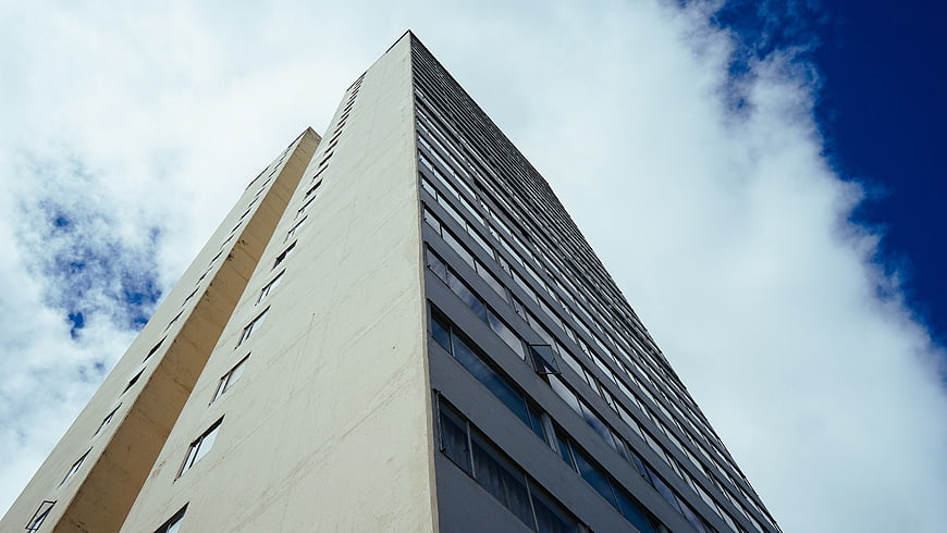 Low angle view of modern high-rise building against blue sky
