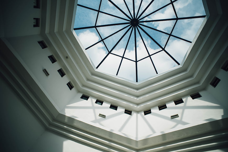 Octagonal skylight with geometric shadows on white ceiling