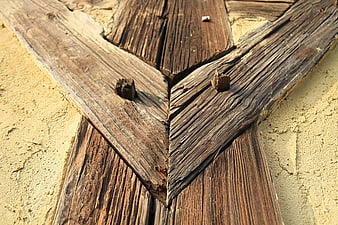 Close-up of weathered wooden planks with nails on a textured wall