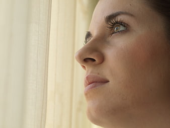 Close-up profile of woman looking out window