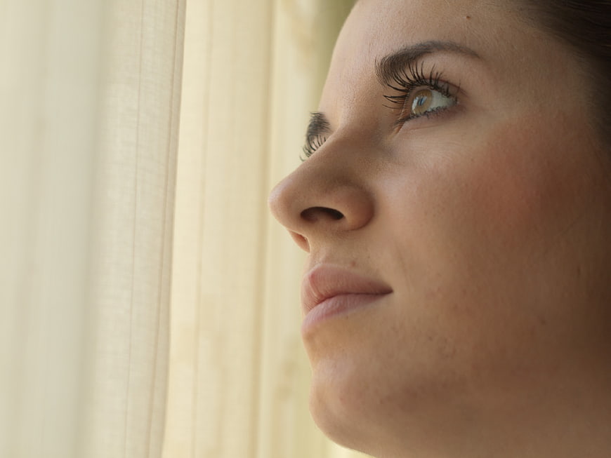 Close-up profile of woman looking out window