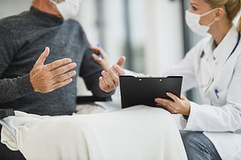 Senior Patient Discussing Health with Masked Doctor