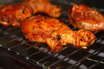 Grilled Chicken Thighs with Red Marinade on Metal Grill Rack