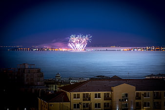 Fireworks Display Over Coastal City at Night
