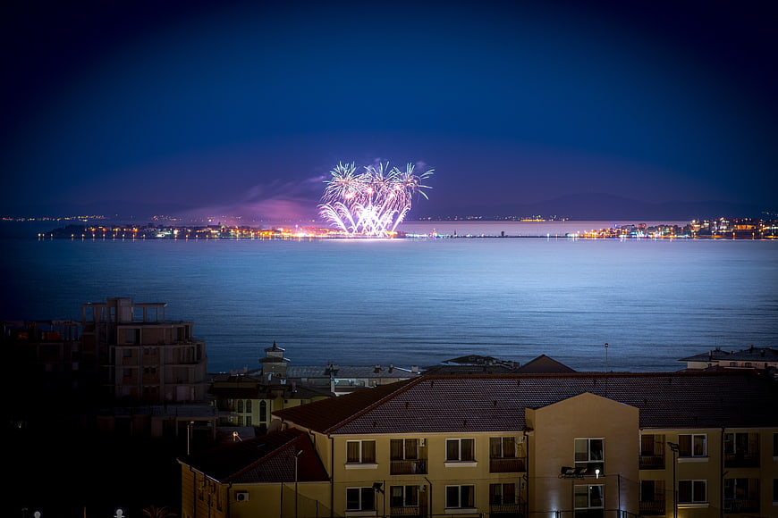 Fireworks Display Over Coastal City at Night