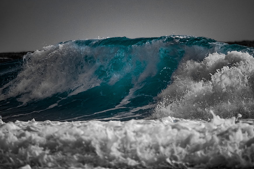 Powerful turquoise ocean wave crashing with white foam