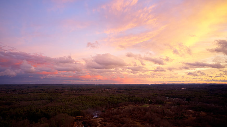 Aerial View of Dramatic Pink and Orange Sunset Over Forest