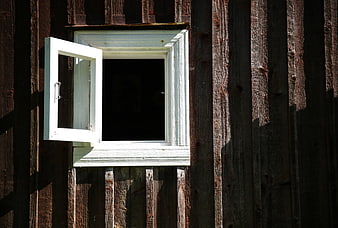 White wooden window on rustic dark wood wall