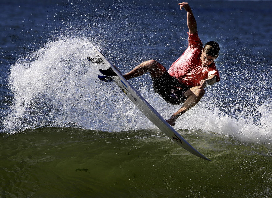 Surfer performing aerial maneuver on ocean wave