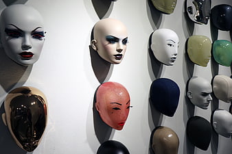 Collection of colorful mannequin heads on a white wall