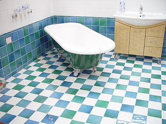 Retro bathroom interior with green and blue checkered tiles and clawfoot tub