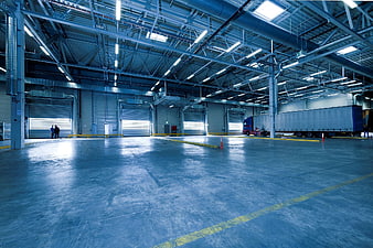 Spacious industrial warehouse interior with loading docks and truck