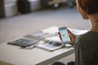 Woman holding smartphone with world map app on screen