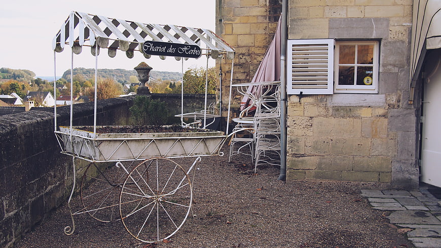 Vintage white herb cart on stone terrace with village view