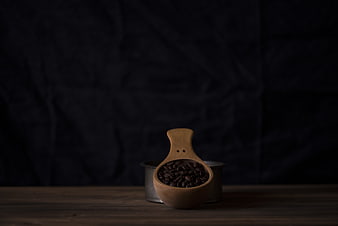Wooden Scoop with Coffee Beans on Dark Background