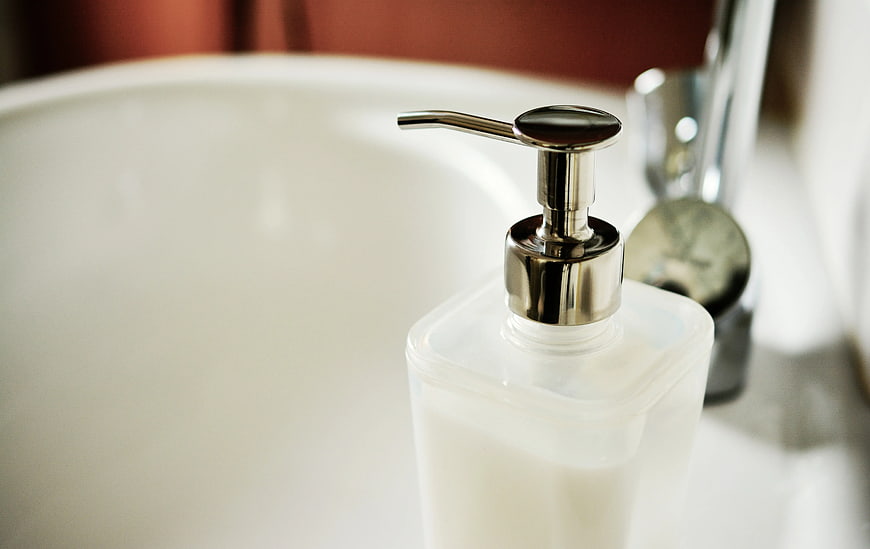 Close-up of white soap dispenser on bathroom sink