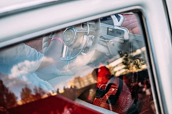 Vintage car interior with driver and sky reflection