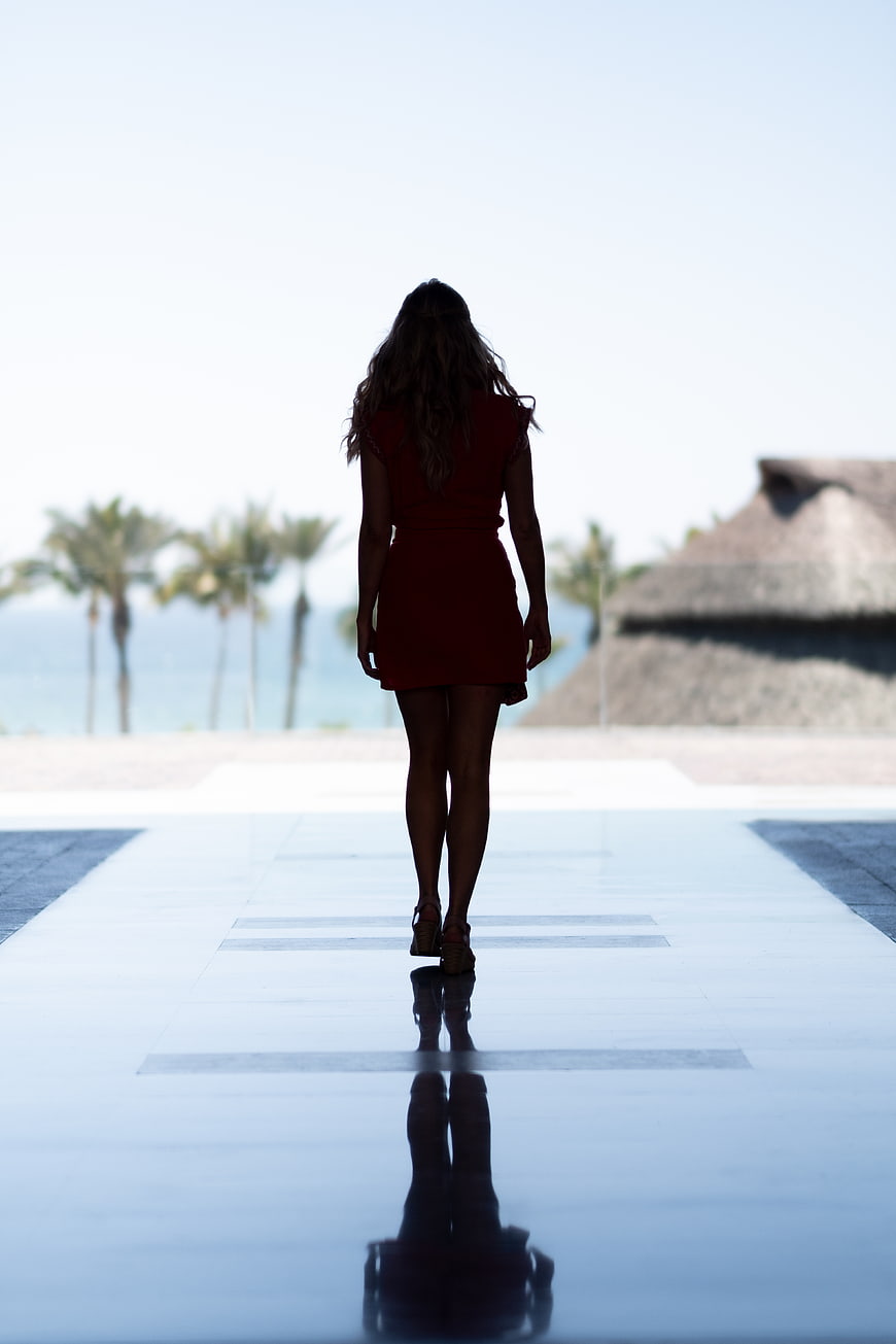 Woman in Red Dress Walking Away with Reflection