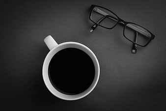 Black and white coffee cup and glasses on dark background