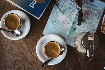 Top view of coffee, map, and camera on wooden table