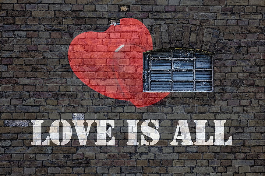 Love Is All Graffiti on Brick Wall with Window