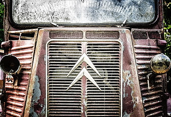 Rusty vintage car grille with emblem and headlights