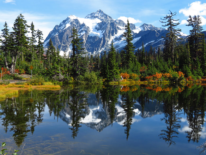 Snowy Mountain Peak Reflected in Calm Forest Pond
