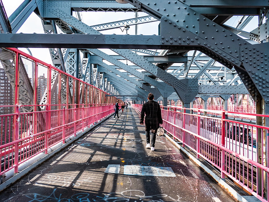 Pedestrians Walking on Industrial Bridge with Pink Railings