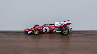 Red vintage die-cast Formula 1 race car model on wood