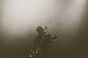 Silhouette of Guitarist Performing on Smoky Stage