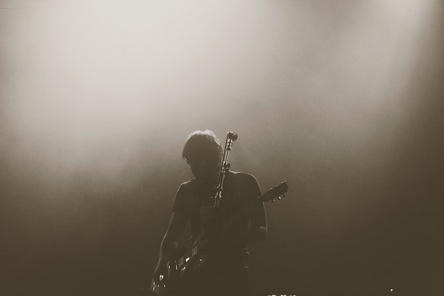Silhouette of Guitarist Performing on Smoky Stage