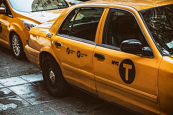Yellow NYC Taxi Cab Parked on Wet City Street