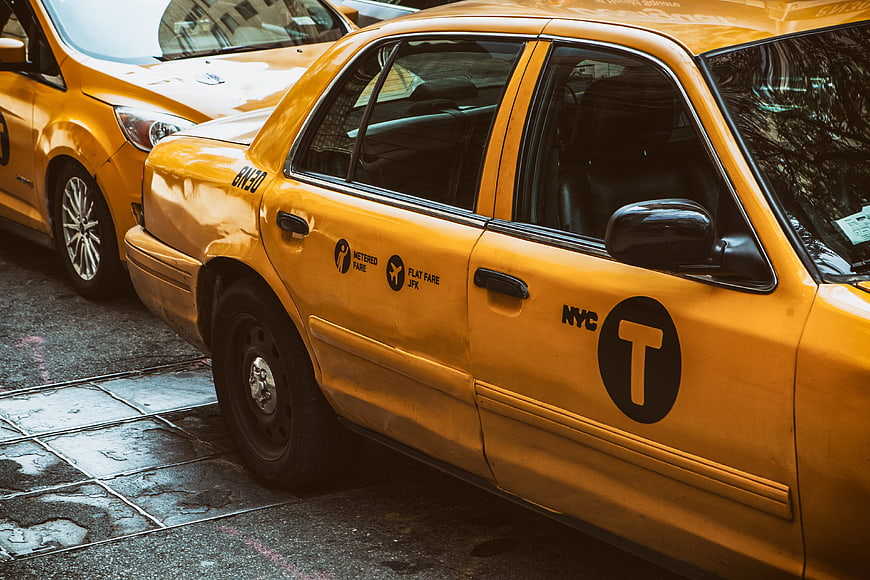 Yellow NYC Taxi Cab Parked on Wet City Street