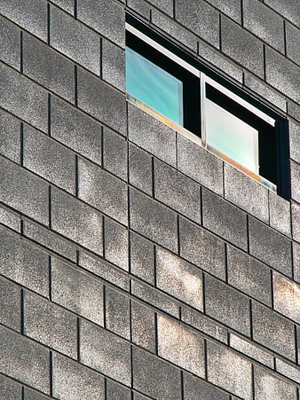 Modern gray brick building facade with diagonal window