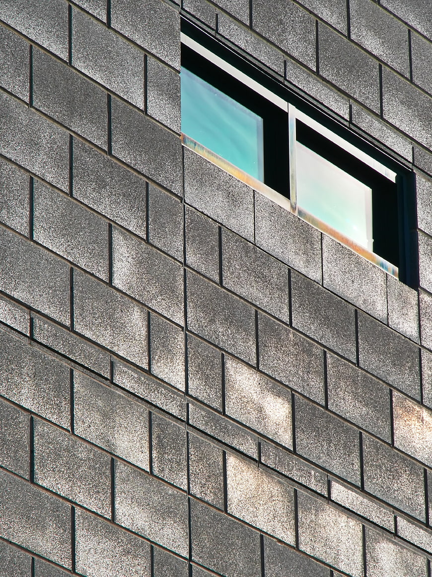 Modern gray brick building facade with diagonal window