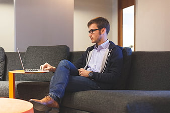 Young man working on laptop in modern office lounge