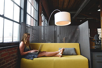 Woman working on laptop in modern office lounge