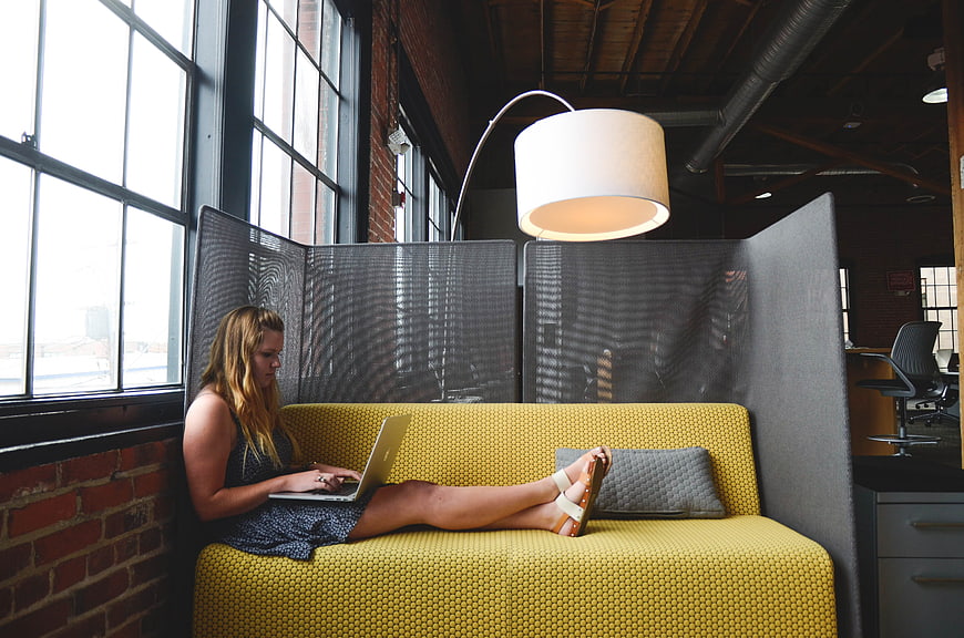 Woman working on laptop in modern office lounge