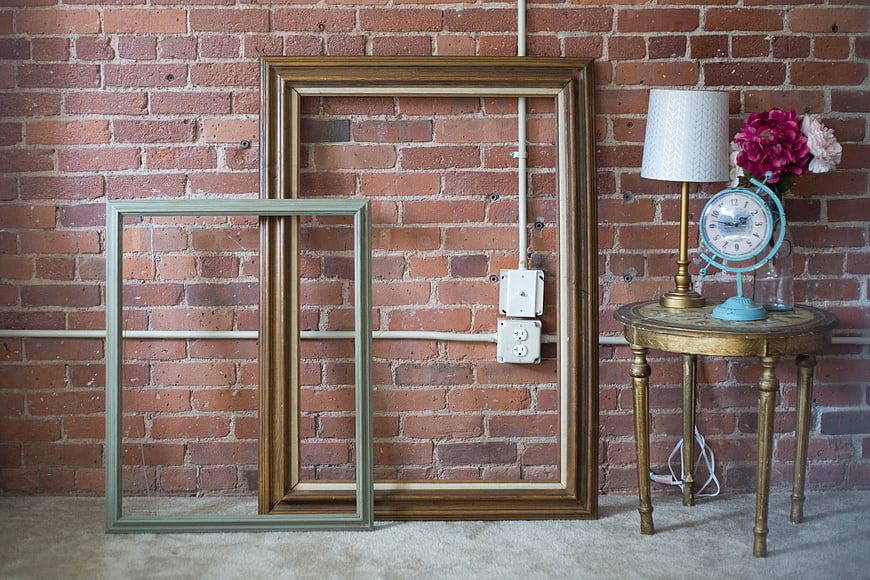 Vintage Picture Frames Leaning Against Exposed Brick Wall