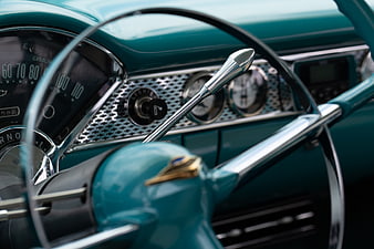 Close-up of vintage teal car dashboard and steering wheel