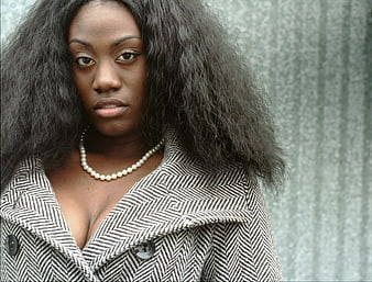 Portrait of Black Woman in Herringbone Coat and Pearl Necklace
