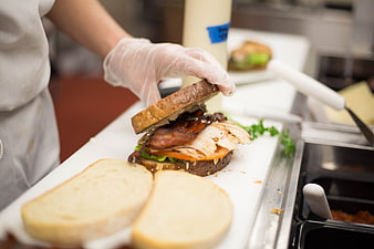 Chef preparing gourmet sandwich in commercial kitchen