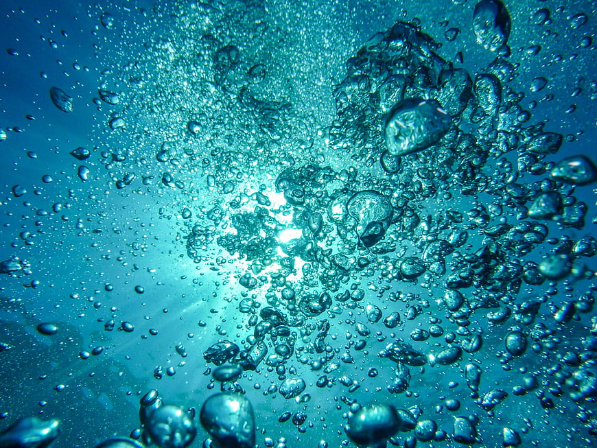 Underwater Bubbles Rising in Blue Ocean Water